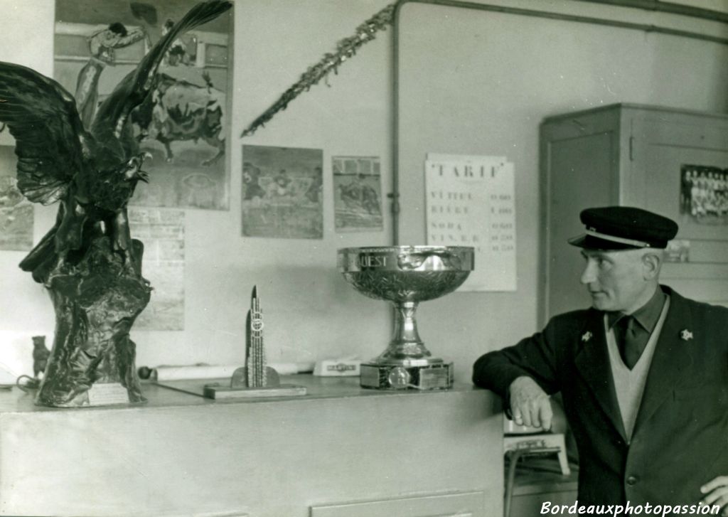 Marcel tenait son bar dans le quartier des coureurs. Il observe attentivement le trophée Yves Du Manoir de rugby.